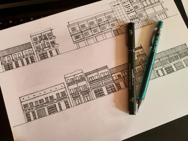 Vue d'angle élevé des stylos et du dessin sur papier sur la table