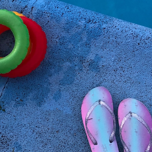 Vue d'angle élevé des tongs avec un jouet au bord de la piscine