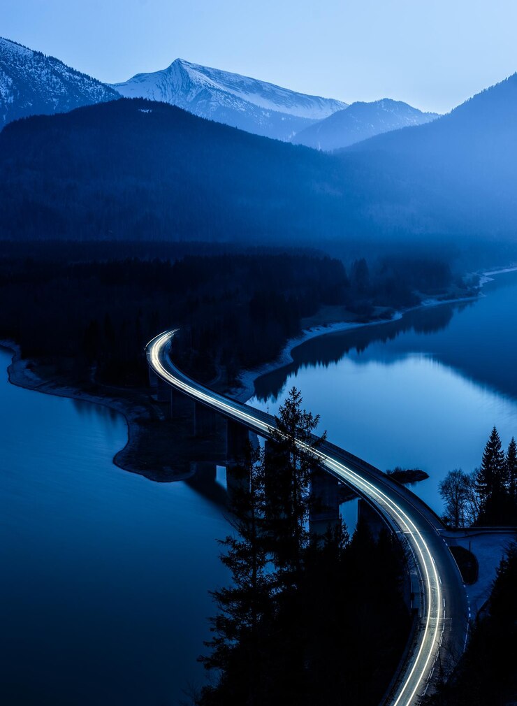 Photo vue d'angle élevé des traces de lumière sur le pont sur la rivière au crépuscule