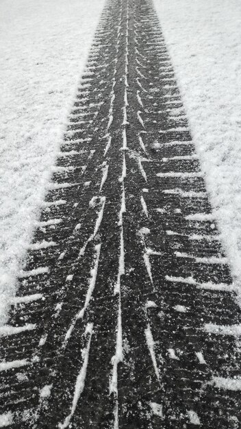 Photo vue d'angle élevé des traces de pneus sur un terrain couvert de neige