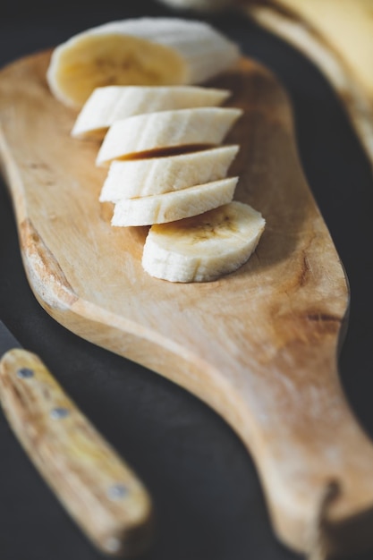 Photo vue d'angle élevé des tranches de bananes sur la planche à couper