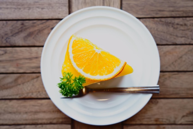 Vue d'angle élevé des tranches d'orange avec de l'herbe dans l'assiette sur la table