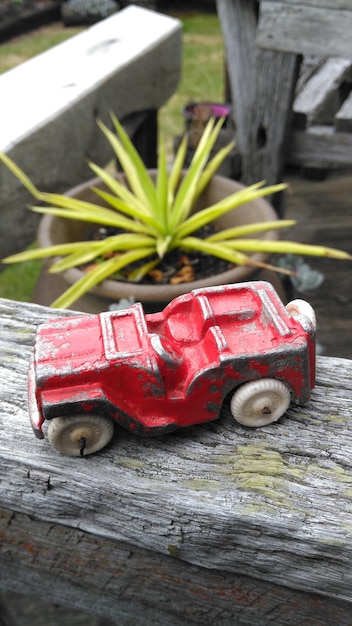 Vue d'angle élevé de la voiture de jouet rouge contre la plante en pot