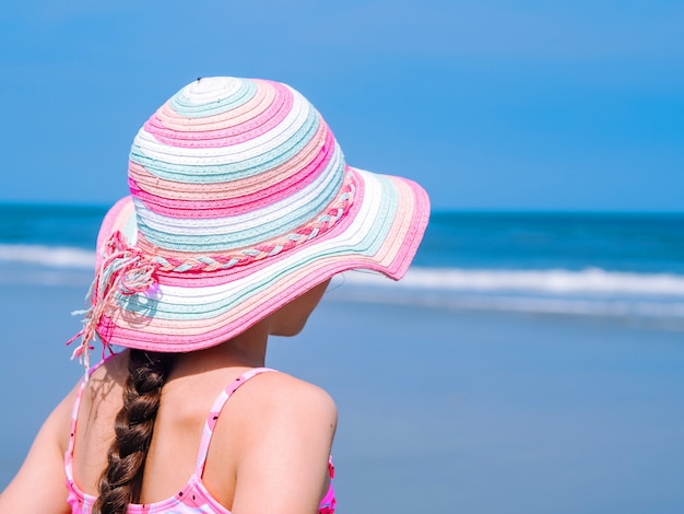 Vue arrière d&#39;une adolescente en profitant de la vue de la plage tropicale.