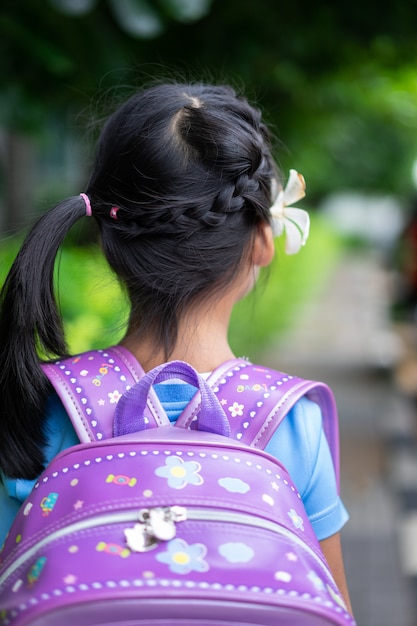 Vue arrière de l'adorable petite fille avec de beaux cheveux, marchant dans le parc