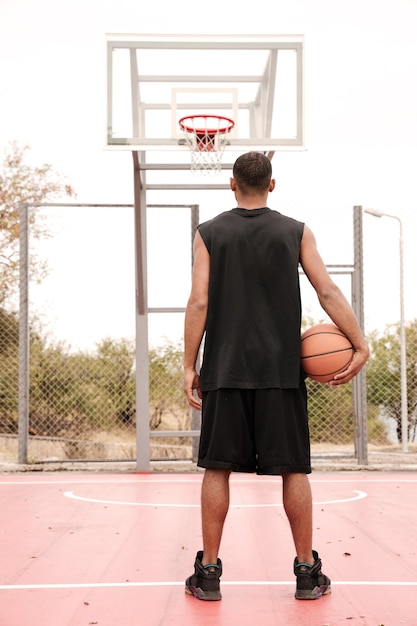 Vue arrière d'un basketteur regardant cerceau, tir au panier en plein air