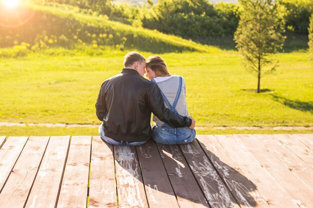 Vue arrière d'un couple assis sur un arbre