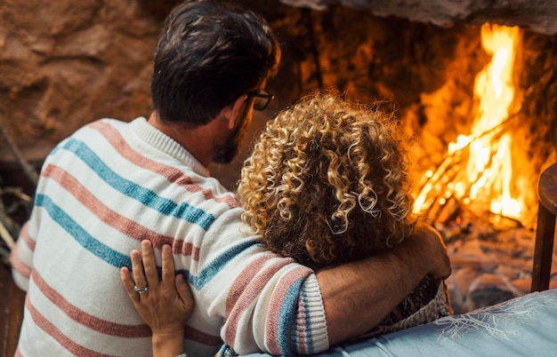 Photo vue arrière d'un couple assis près de la cheminée