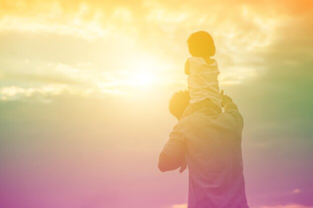 Vue arrière d'un couple debout contre le ciel au coucher du soleil