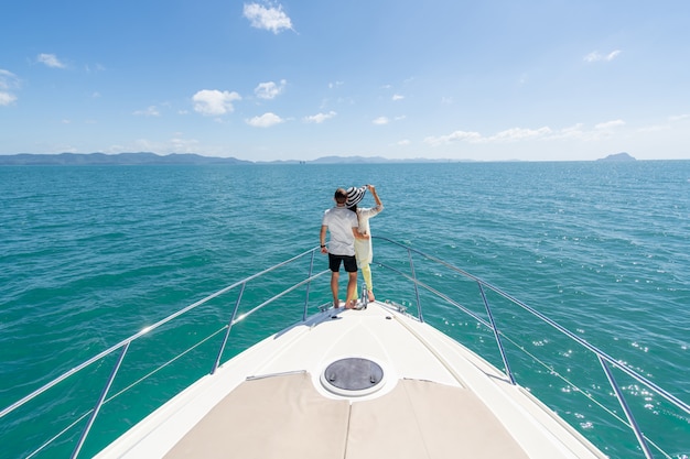 Vue arrière d'un couple doux debout sur le bord d'un yacht de luxe