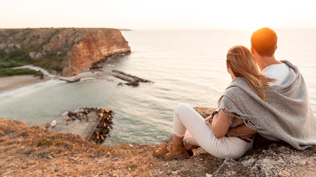 Photo vue arrière couple profitant du coucher de soleil avec espace copie