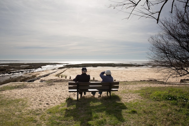 Vue arrière d'un couple senior romantique heureux assis sur un banc de parc