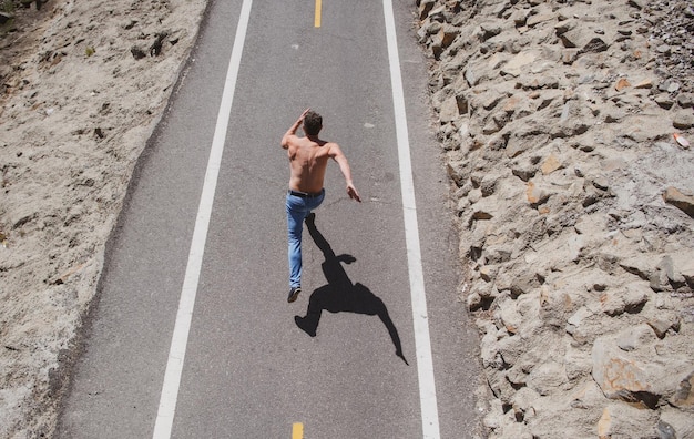 Vue arrière d'un coureur qui court du jogging sur la route