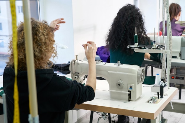 Photo vue arrière des créateurs de mode travaillant à l'atelier