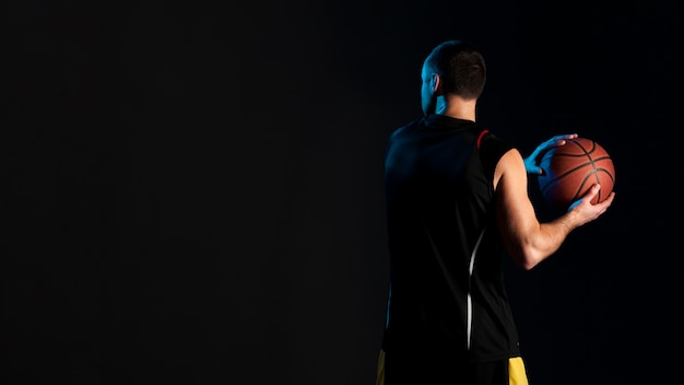 Photo vue arrière du basketteur avec ballon et espace copie