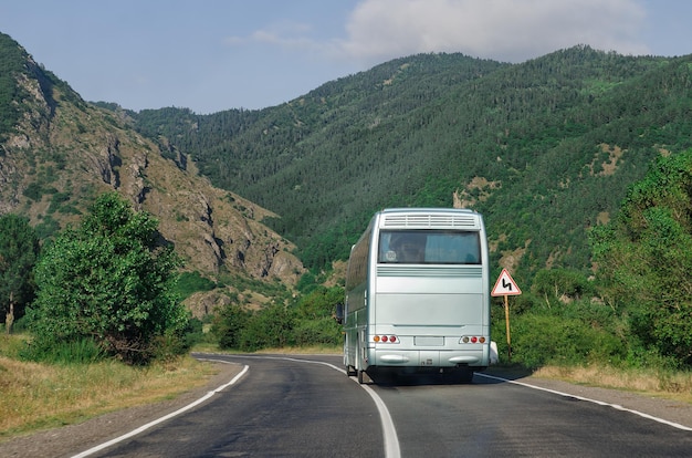 Vue arrière du bus sur la route de montagne Derrière l'espace de copie du bus blanc