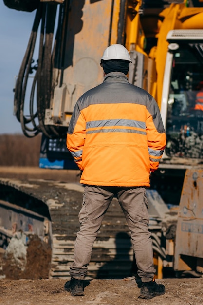 Vue arrière du directeur ingénieur industriel debout et vérifiant la structure et de la construction du pont