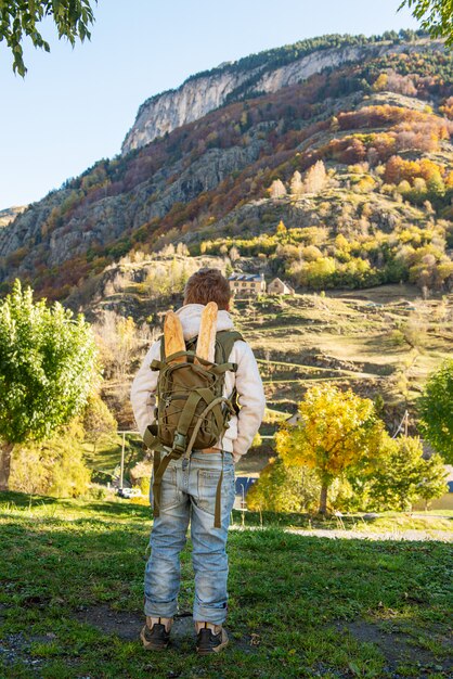 Vue arrière du garçon avec sac à dos dans les montagnes d'automne