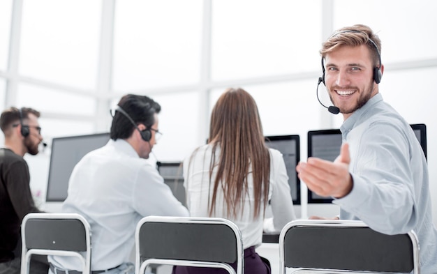 Vue arrière du jeune agent du service client assis à son bureau