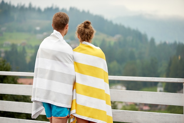 Vue arrière du jeune couple debout sur la terrasse.