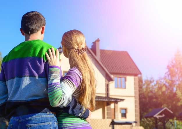 Vue arrière du jeune couple regardant leur nouvelle maison