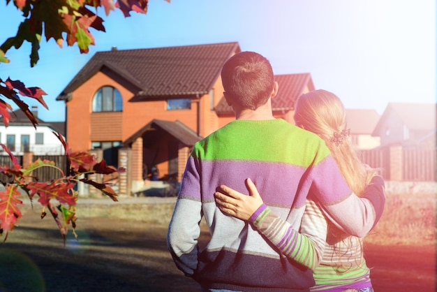 Vue arrière du jeune couple regardant leur nouvelle maison