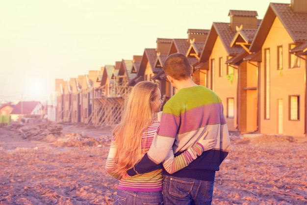 Vue arrière du jeune couple regardant leur nouvelle maison