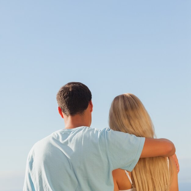 Vue arrière du joli couple admirant le ciel bleu