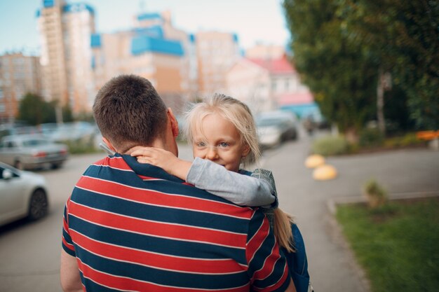 Vue arrière du père retournant à l'école avec sa petite fille.