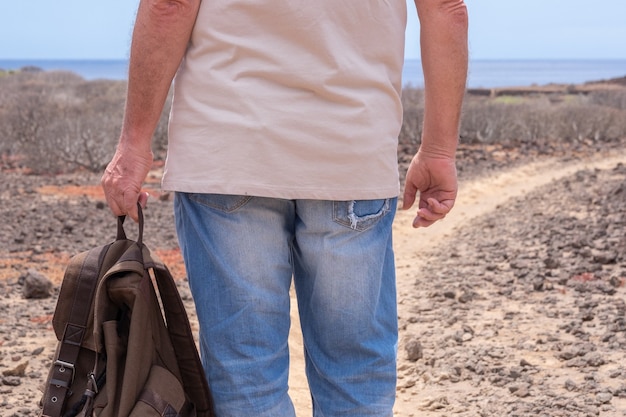 Vue arrière du voyageur homme tenant un sac à dos profitant d'une excursion en plein air Horizon sur la mer