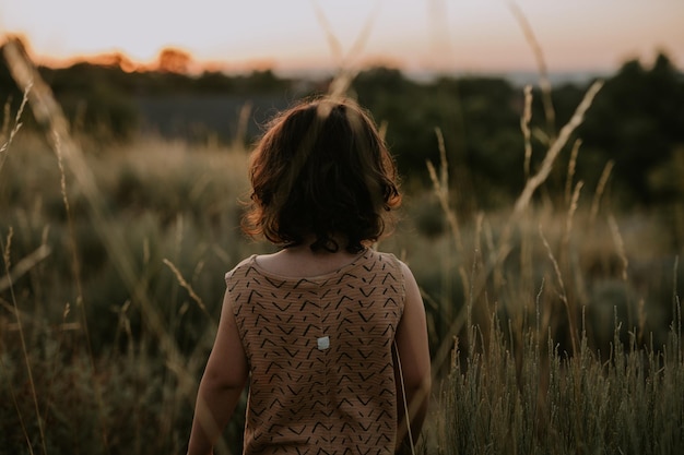 Vue arrière enfant debout dans les champs