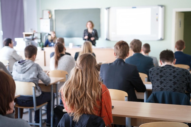 Vue arrière d'étudiants assis dans une salle de classe
