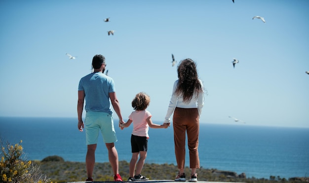 Vue arrière de la famille insouciante sur les vacances à la plage