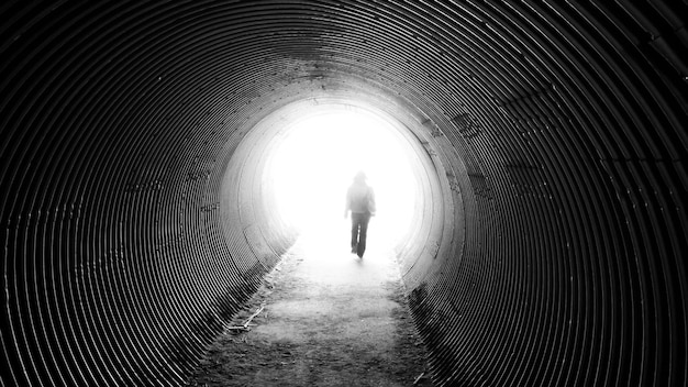 Vue arrière d'une femme adulte à mi-âge marchant dans un tunnel