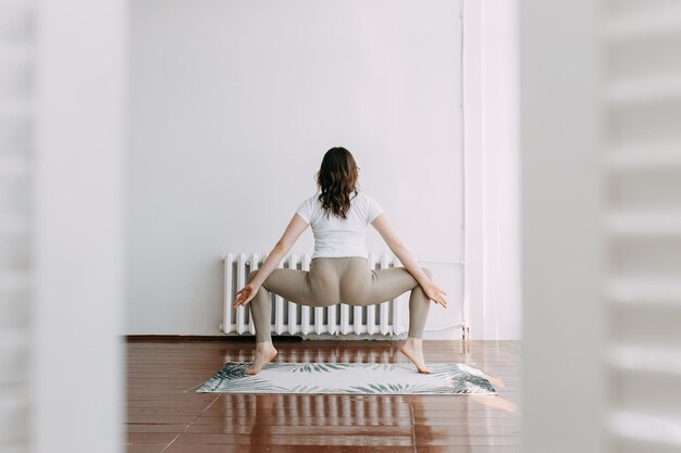 Photo vue arrière d'une femme assise sur une chaise contre le mur