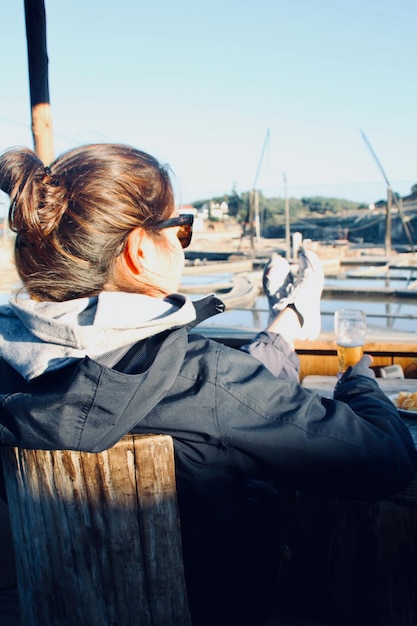 Photo vue arrière d'une femme assise contre le ciel