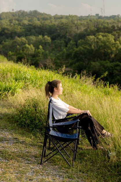 Vue arrière d'une femme assise sur l'herbe