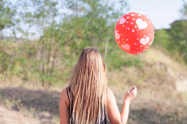 Photo vue arrière d'une femme avec un ballon rouge