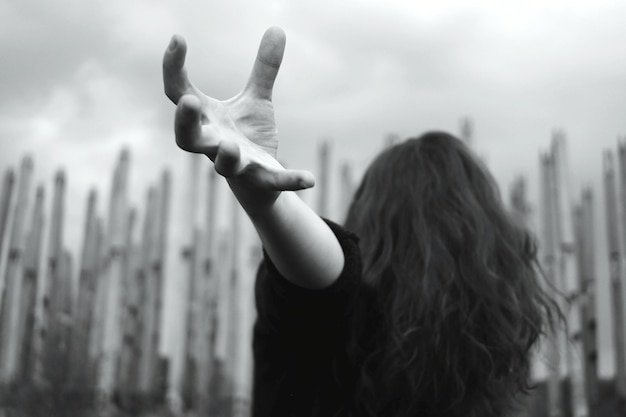 Photo vue arrière d'une femme avec les bras levés debout contre un fond flou