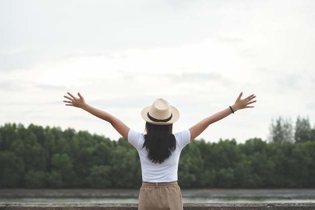 Vue arrière d'une femme avec les bras tendus debout contre le ciel