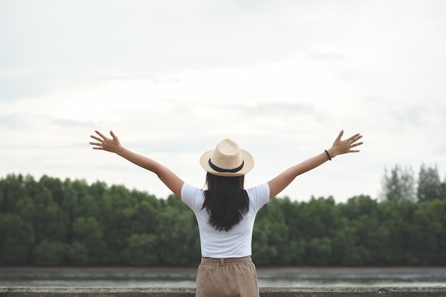 Photo vue arrière d'une femme avec les bras tendus debout contre le ciel