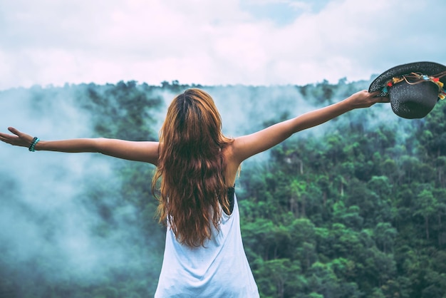 Vue arrière d'une femme avec les bras tendus debout contre le ciel
