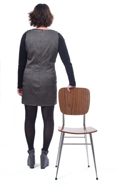 Vue arrière d'une femme avec une chaise en fond blanc
