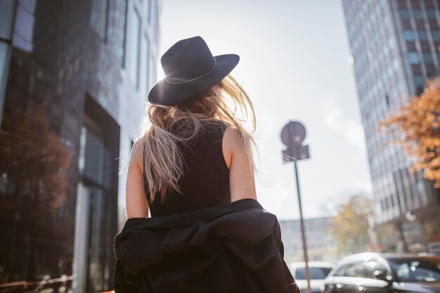 Vue arrière de la femme avec un chapeau vêtu de noir