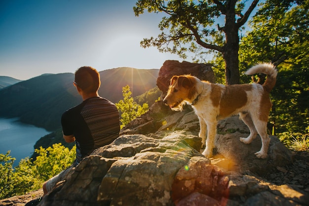 Photo vue arrière d'une femme avec un chien sur la montagne contre le ciel