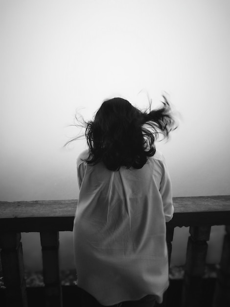 Vue arrière d'une femme contre un ciel nuageux