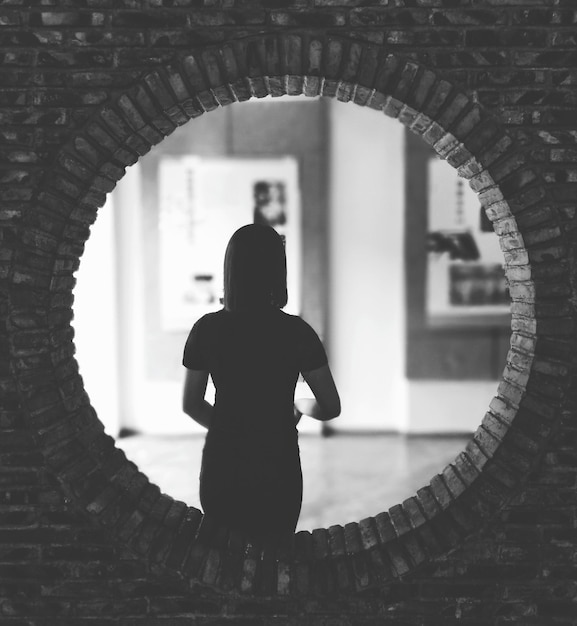 Vue arrière d'une femme dans le couloir d'un bâtiment historique