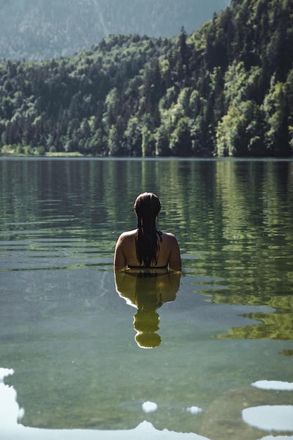 Photo vue arrière d'une femme dans un lac à la forêt