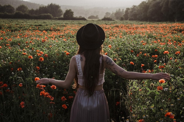 Vue arrière d'une femme debout au milieu de plantes à fleurs
