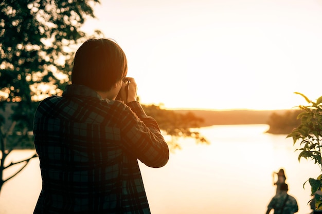 Photo vue arrière d'une femme debout contre le ciel au coucher du soleil